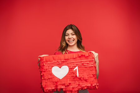 Smiling Woman Holding a Valentines Day Themed Red Cardboard Design
