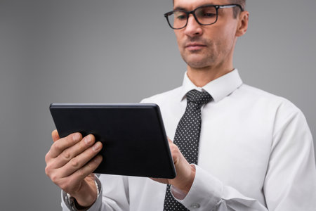 Professional Man Using Tablet Device in Office Environment for Workの写真素材