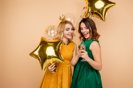 Two Stylish Women Celebrating with Balloons and Champagne at a Partyの写真素材