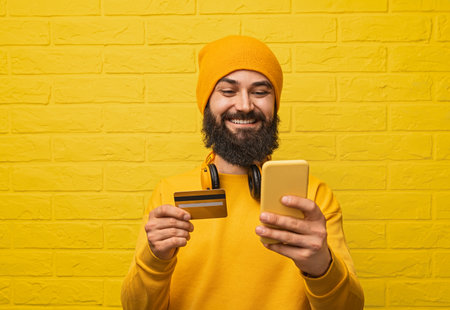 Smiling Man Using Smartphone for Online Payment with Credit Cardの写真素材