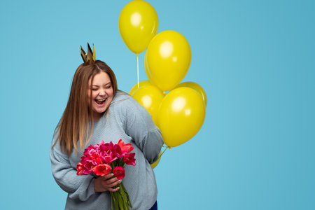 Happy woman with bouquet of flowers and balloonsの写真素材