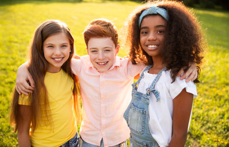 Happy Smiling Children Enjoying Their Time Outdoors Together in the Sunny Parkの写真素材