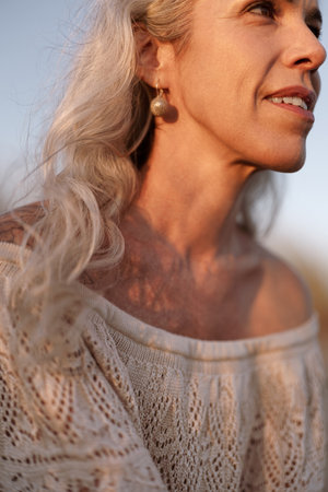 Elegant Woman Enjoying a Tranquil Moment in Sunlit Afternoonの写真素材