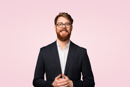 Confident Businessman With Beard in a Suit Smiling Against a Pink Backgroundの写真素材