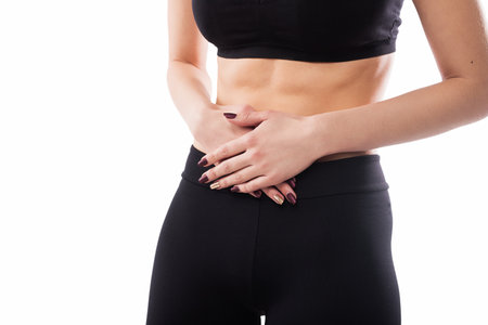 Close-Up of a Woman Having Abdominal Discomfort in Black Athletic Wearの写真素材