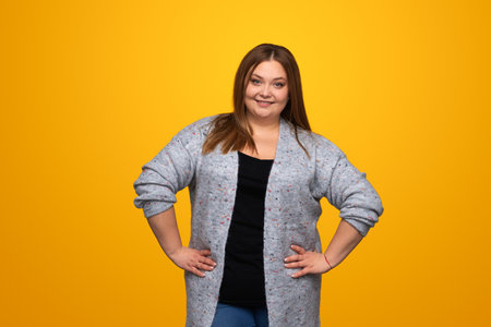 Smiling overweight woman with hands on waistの写真素材