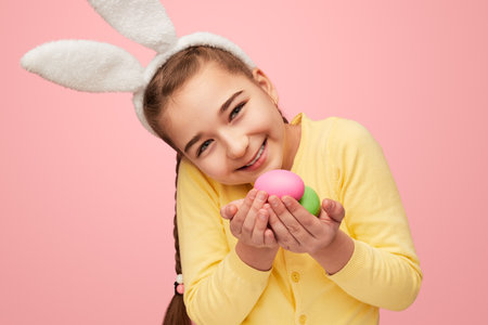 Happy girl holding colored Easter eggsの写真素材