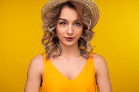 Portrait of a Stylish Woman Posing Against Yellow Backgroundの写真素材