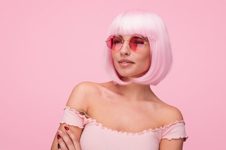 Stylish Woman in Pink Outfit With Sunglasses Against Matching Backgroundの写真素材