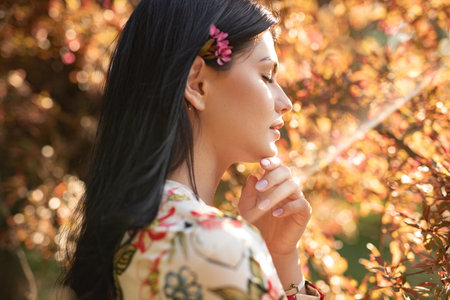 Portrait of a Woman in Autumn Setting with Sunlit Foliageの写真素材