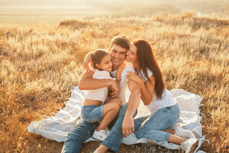 Happy Family Relaxing Outdoors During a Sunny Day in Grassland Environmentの写真素材