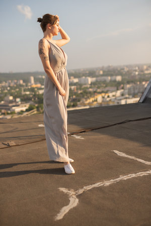 Confident Woman Standing Outdoors with Urban Cityscape During Golden Hourの写真素材
