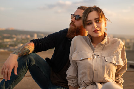 Young Couple Relaxing Outdoors During Sunset on Urban Rooftopの写真素材