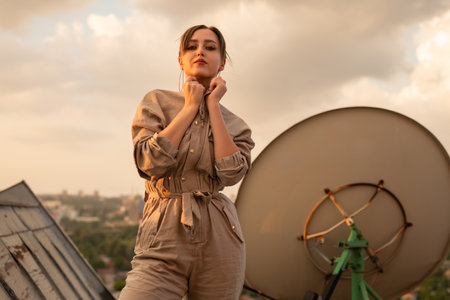 Confident Woman on Rooftop at Sunset With Urban Backdropの写真素材