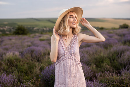 Woman Smiling in a Vibrant Lavender Field Under a Sunny Blue Skyの写真素材