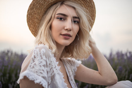 Woman in a Summer Hat Posing Outdoors During Golden Hourの写真素材