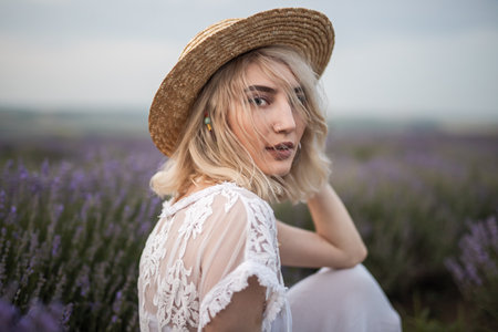Portrait of a Blonde Woman in Lavender Field with Straw Hatの写真素材