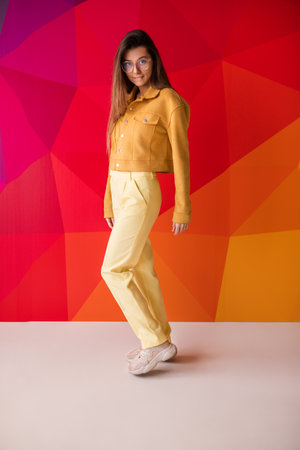 Stylish Woman in Vibrant Studio Against a Modern Geometric Backgroundの写真素材