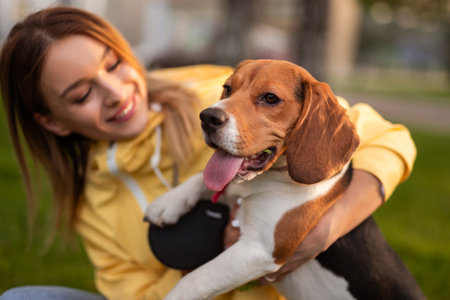 Joyful Woman Spending Time Outdoors with Her Playful Beagle Dogの写真素材