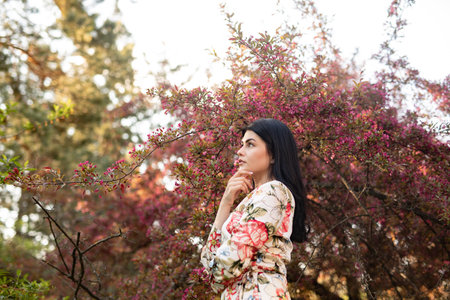 Portrait of a Woman Among Blossoming Trees in a Spring Gardenの写真素材