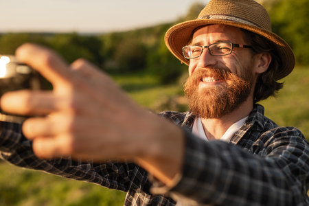 Smiling Man in Casual Wear Taking Photographs Outdoorsの写真素材