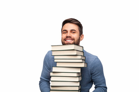 Smiling Young Man Posing with a Stack of Books on White Backgroundの写真素材