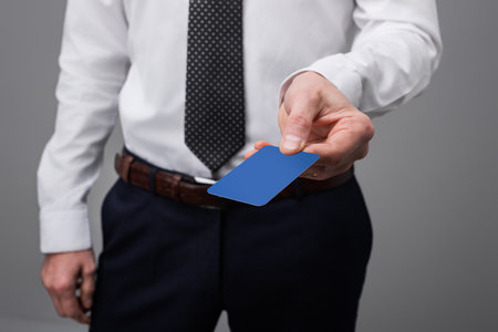 Businessman Holding a Blue Card Representative of Professional Transactionsの写真素材