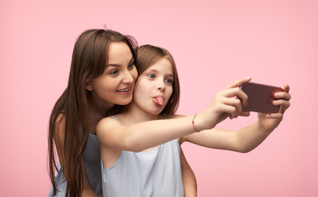 Mother and daughter grimacing for selfieの写真素材