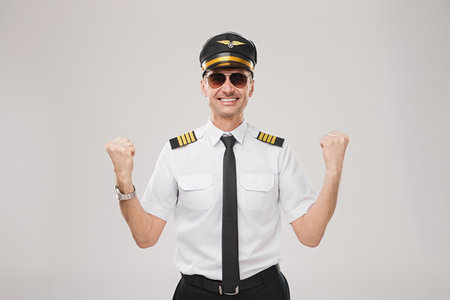 Confident Airline Pilot Celebrating Success in Uniform with Positive Energyの写真素材
