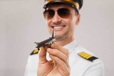 Commercial Pilot Displaying a Scale Model Aircraft in Uniform with Confidenceの写真素材