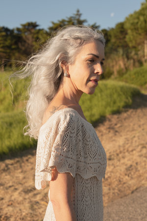 Elegant Woman With Gray Hair Enjoying a Sunny Day Outdoorsの写真素材