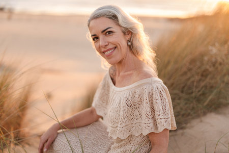 Portrait of a Smiling Woman on a Sandy Beach at Sunsetの写真素材