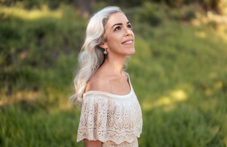 Content Woman With Grey Hair Enjoying Nature in a Sunny Parkの写真素材
