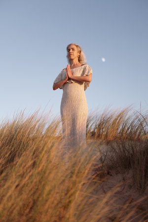 Serene Meditation On Sand Dunes During Sunsetの写真素材