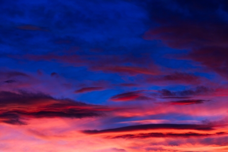 An intensely colorful sunset sky with clouds の写真素材