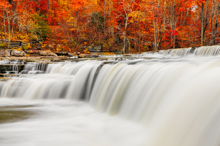 Brilliant autumn foliage surrounds the falling whitewater of Upper Cataract Falls, an Indiana...