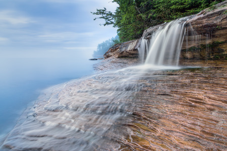 Elliot Falls, a small but beautiful waterfall on Miner's Beach at Michigan's Pictured Rocks National Lakeshore, spills over rock ledges and into Lake Superior after sundown.の写真素材
