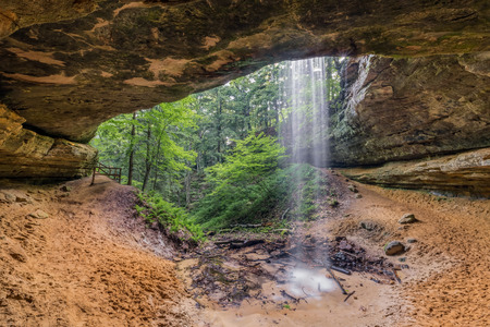 Memorial Falls, a waterfall in a wooded area near Munising, Michigan, is viewed here from the alcove cave behind the falls.の写真素材