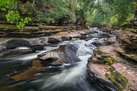 Upper Peninsula Michigan's Presque Isle River cascades over ledges and swirls in potholes carved by the current into the riverbed at Porcupine Mountains Wilderness State Park.の写真素材