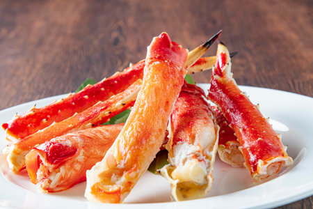 King crab legs on a white plate on a wooden background. Seafood.の写真素材