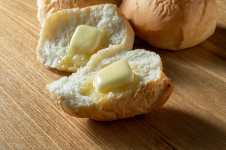 Bread with butter on a wooden background. Close-up.Let's eat fresh and delicious butter for breakfast.の写真素材