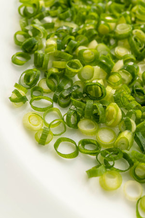 chopped green onions on a white plate, close-up, macroの写真素材