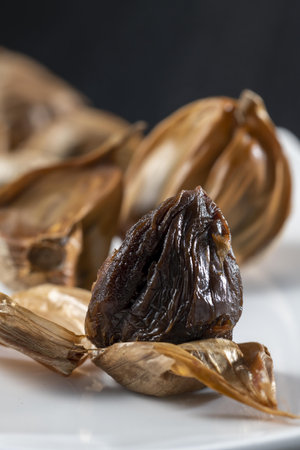 Close up of dried dates on a white plate with black background.の写真素材