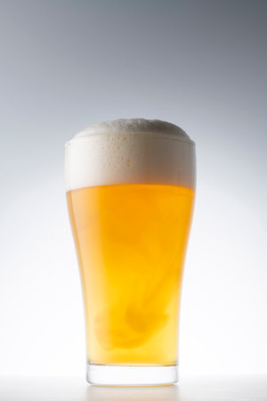 Glass of beer with foam on a white background. Studio shot.の写真素材
