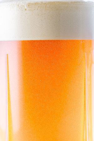 Close up of beer foam in a glass isolated on white background.の写真素材