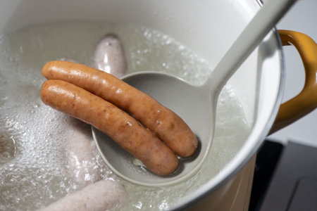 Boiling sausages in a pot on a gas stove.の写真素材