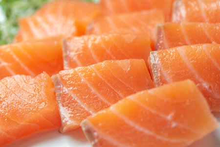 Slices of fresh salmon on a white plate, closeupの写真素材