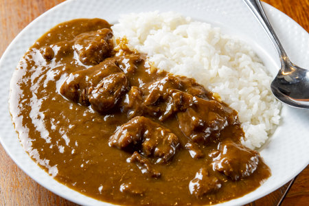 Beef curry with rice on a wooden table, close-upの写真素材