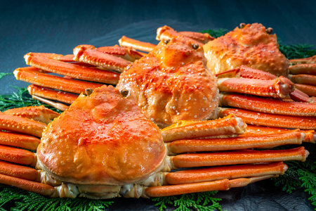 Cooked crab legs on a black plate with dill and spicesの写真素材