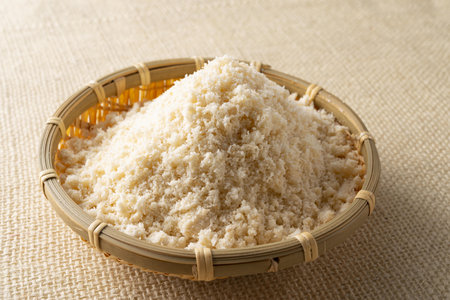 Powdered rice in bamboo sieve on burlap backgroundの写真素材